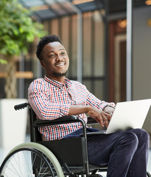 Man in a wheelchair using a laptop