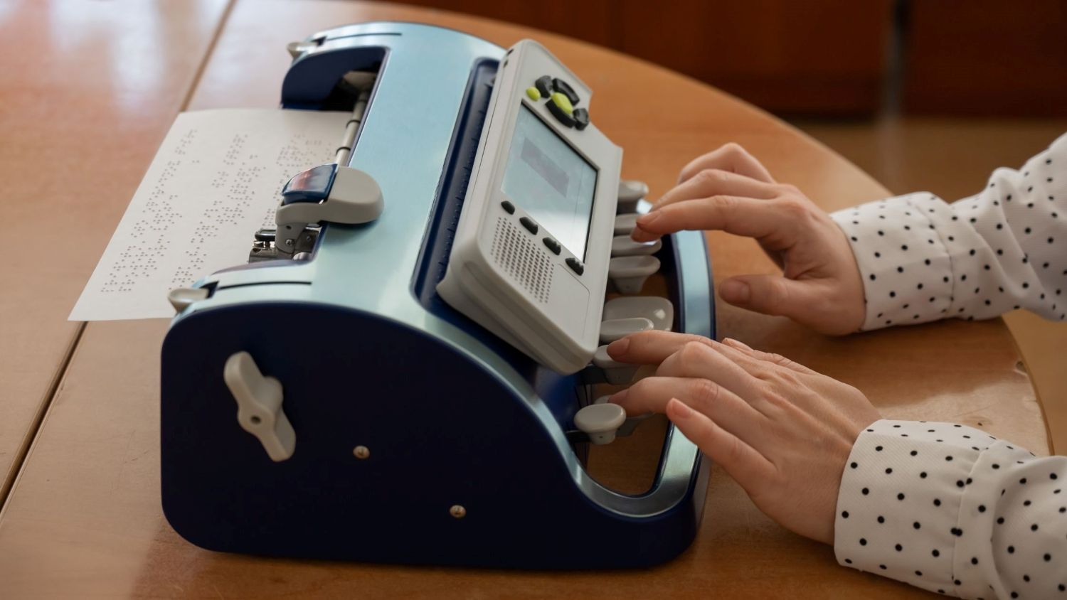 An individual using a modern Braille embosser