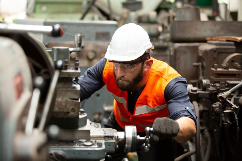 Factory worker operating machine